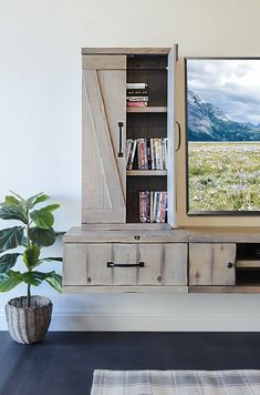 an entertainment center with bookshelves and a flat screen tv mounted on the wall