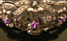 "Just gorgeous vintage estate antiqued sterling silver, marcasite and amethyst hinged bracelet, featuring three heavily faceted and prong set round soft purple colored amethysts surrounded by floral shapes encrusted with dazzling marcasite; and a contrasting highly polished open silver work design at sides and back. Hinged bracelet has wearable (interior) length of approximately 6 1/2\" and width of 13/16\"; substantial piece with total weight of 30.7 g. Box clasp closure with safety clasp on to Antique Silver Jeweled Jewelry, Antique Jeweled Silver Jewelry, Antique Silver Jewelry With Prong Setting, Luxury Vintage Sterling Silver Cuff Bracelet, Victorian Marcasite Jewelry For Anniversary, Luxury Vintage Antique Silver Cuff Bracelet, Vintage Silver Amethyst Bracelets, Antique Multi-stone Bracelets As Gift, Luxury Vintage Oxidized Sterling Silver Bracelet