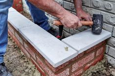 a man is holding an hammer and building a brick wall with it's bricks