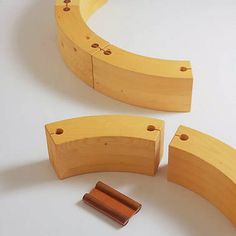 three pieces of wood sitting next to each other on a white surface with one piece missing