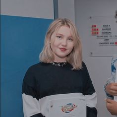 a woman standing in front of a blue wall holding a water bottle and an award