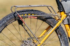 the front wheel of a bike with a yellow frame