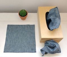 a table topped with a potted plant next to a wooden box filled with blue cloth