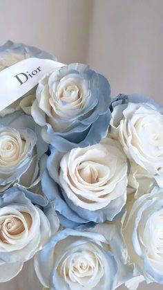 a bouquet of white and blue roses with a name tag on the top that says diot