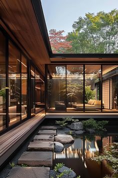 the inside of a house with a pond in front of it and lots of windows