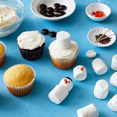 cupcakes decorated with marshmallows and chocolate chips on a blue surface