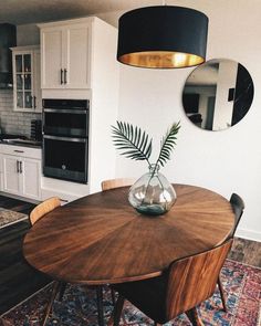 a dining room table with chairs and a vase on it