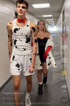 two people dressed up in costumes walking down a hallway together, one is wearing a dalmatian costume and the other has a red bow tie