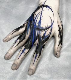 a person's hand with blue and black ink on it