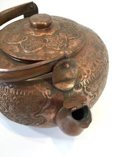 an antique teapot with ornate designs on it's lid and handle is shown