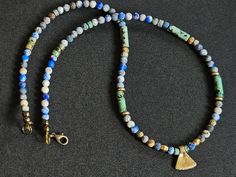 Handmade necklace, inspired by ancient Egyptian jewellery. Made of  small, faceted Lapis lazuli beads ( size about 4mm ) , Turquoise beads ( heishi and tubes ), brass beads and small charm. Necklace is fastened with lobster clasp.  Approx length  -  47 cm / 18.50 inch. Blue Beaded Turquoise Amulet Necklace, Blue Beaded Amulet Style Turquoise Necklace, Blue Gemstone Beads Amulet Necklace, Spiritual Blue Turquoise Necklace With Faceted Beads, Spiritual Blue Turquoise Necklace With Spacer Beads, Ancient Style Gemstone Beads Jewelry Gift, Ancient Style Gemstone Beads Jewelry For Gift, Blue Amulet Beads For Gifts, Blue Amulet Beads For Gift