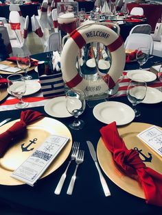 a table set with plates, silverware and napkins for an ocean themed party