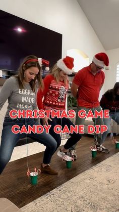 three people in christmas hats are playing with candy cane dips