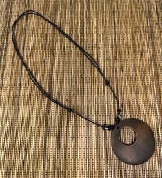 Discover the elegance of nature with our Brown Circle Pendant Necklace, a perfect blend of style and natural beauty. This unisex necklace features a meticulously crafted wooden pendant, showcasing a beautiful wood design that captures the essence of the earth's simplicity and grace. Pendant Specifications:     Size: 2.25 inches in diameter, offering a prominent yet comfortable size.     Material: High-quality wood, chosen for its durability and natural aesthetics. Necklace Features:     Adjustab Brown Necklace With Adjustable Cord And Round Pendant, Adjustable Wood Jewelry Nature-inspired, Adjustable Wood Jewelry In Nature-inspired Style, Adjustable Natural Wood Necklace Nature-inspired, Adjustable Rustic Necklace With Round Pendant, Brown Wooden Beads Holistic Necklace, Rustic Adjustable Round Pendant Necklaces, Holistic Brown Necklaces With Wooden Beads, Adjustable Nature-inspired Wooden Jewelry