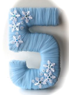 the letter s is decorated with snowflakes and blue furnishing on it