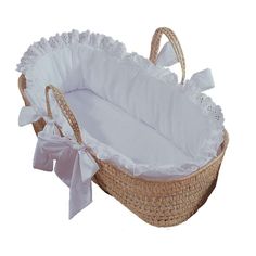 a baby bassinet with white ruffles and bows on the handle is shown