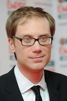 a man wearing glasses and a black suit