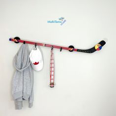 a hockey stick and glove hang on the wall next to a scarf rack with sports memorabilia