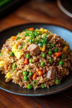 a plate with rice, peas and meat on it sitting on a table next to some vegetables