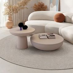 a modern living room with white furniture and flowers in the vases on the table