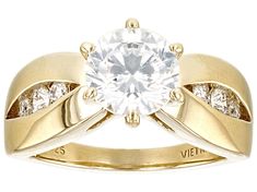 a yellow gold ring with a diamond in the center and two diamonds on each side