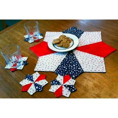 a wooden table topped with red, white and blue quilted place mats covered in stars