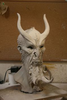 a white mask with horns on top of a table