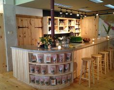 a kitchen with wooden floors and lots of counter top space next to a bar that has candles on it