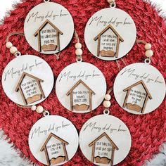 six dog houses with names on them are hanging from a red rug in the shape of a christmas ornament