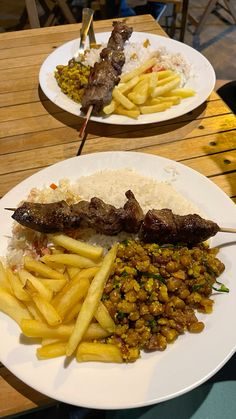 two plates filled with food on top of a wooden table