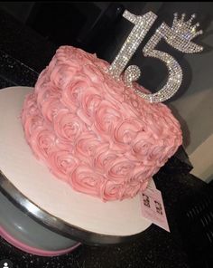 a pink cake that is on top of a white plate with a number 15 on it