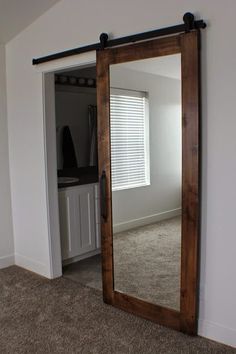 an empty room with a large mirror on the wall and a closet in the background