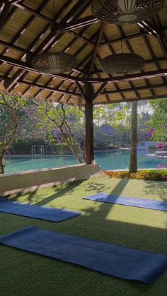 yoga mats are laid out on the grass in front of a gazebo and lake