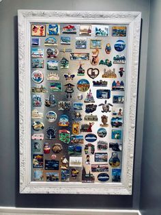 a white frame filled with lots of different types of magnets on the side of a wall