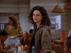 a woman with glasses standing in front of a table full of people at a restaurant