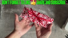 someone is holding up a red and white box with candy canes on it that says don't forget to like share and sub describe