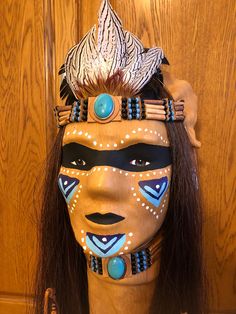 Leather stretched across face mask and hand painted with beads and feathers with genuine horsehair. The mask is securely attached to a Polynesian teak wood stand, approximately 30" with a felt bottom, making this a portable piece of southwest decor. Will look great on an end table, desk, fireplace mantle, ect. Doesn't take up very much room, very lightweight. Desk Fireplace, Native American Masks, Southwest Decor, Native American Style, Securely Attached, Native American Fashion, Warrior Princess, Fireplace Mantle, Wood Stand