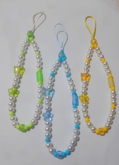 three necklaces with different colored beads on them