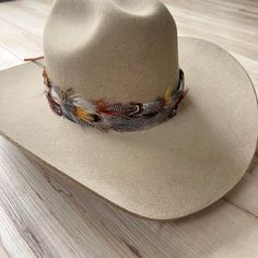 Natural feather hat band. Adjustable with a leather tie. Natural colored feathers Adjustable hatband Approx. 4 cm wide *This product is for 1 single hat band. Hat not included. Width Options: 3 cm and 4 cm. Made from natural feathers for an authentic and unique appearance. Adjustable with leather lace ties to fit most hat sizes. Adds a touch of sophistication and elegance to any hat for any occasion Length: 57 cm, not including leather ties. Adjustable Brown Hat Bands With Flat Bill, Country Style Adjustable Felt Hat With Flat Bill, Adjustable Country Style Felt Hat With Flat Bill, Adjustable Felt Hat For Western-themed Events With Flat Bill, Adjustable Flat Bill Felt Hat For Western-themed Events, Adjustable Brown Felt Hat With Flat Bill, Custom Adjustable Brown Felt Hat, Adjustable Beige Felt Hat For Ranch, Feather Hat Band