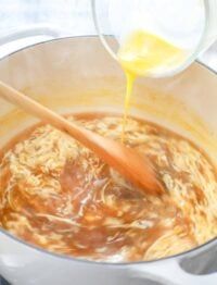 a wooden spoon is being used to stir food in a pot