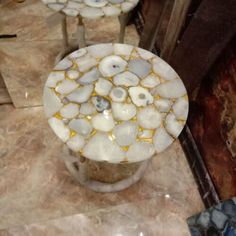 two marble tables sitting on top of a tiled floor