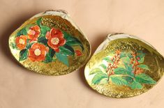 two gold plates with flowers painted on them