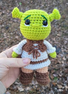 a small crocheted stuffed animal is being held up by someone's hand