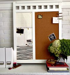 a bulletin board with some papers on it and a potted plant next to it