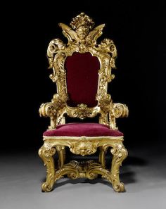 an ornate gold chair with red velvet upholstered on the back and seat cushion