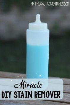 a blue bottle with the words miracle diy stain remover next to it on a wooden table