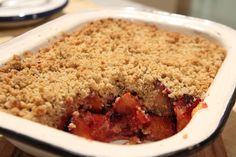 a close up of a casserole dish with fruit in it on a table