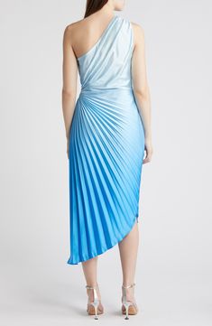 a woman wearing a blue dress with one shoulder draped over it