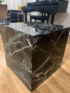 a black marble table with a piano in the background