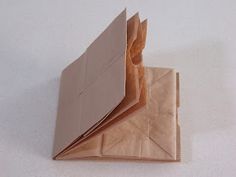 an origami folded in half on a white surface